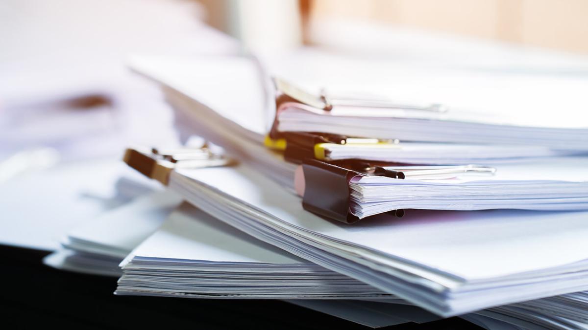 Photo of stacks of documents clipped together.