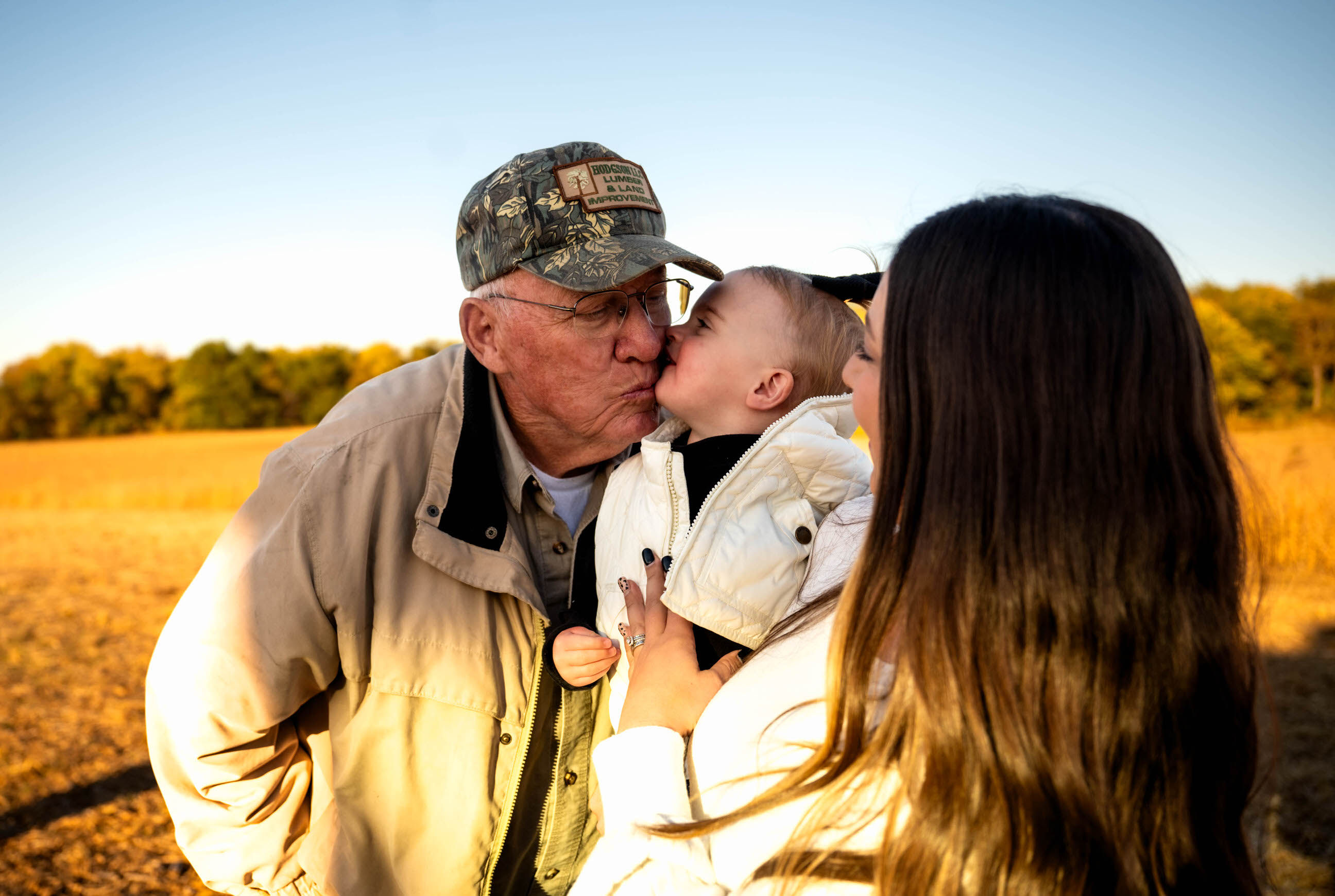 Photo of a grandfather kissing a small child.